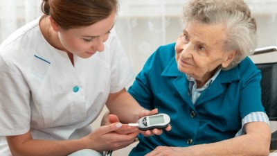 Nurse checks patient's blood sugar