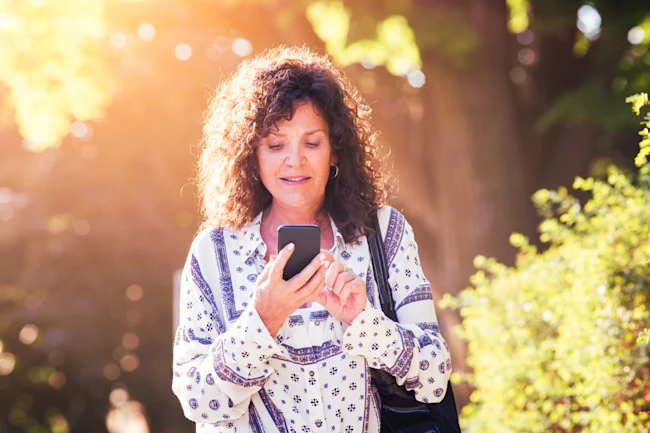 Mature woman playing video game on mobile phone