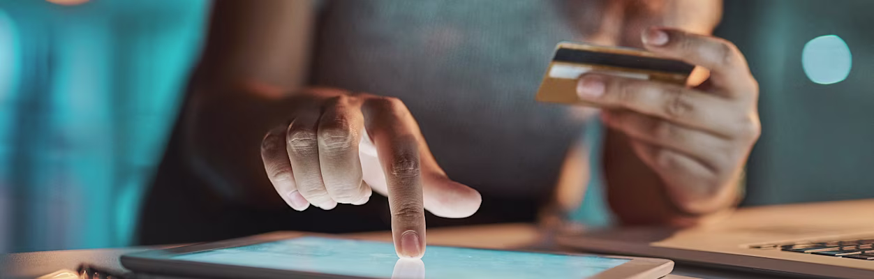 Businesswoman using her tablet and card to make payments
