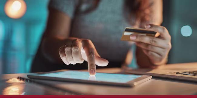 Businesswoman using her tablet and card to make payments