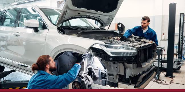 Two service technicians inspect the car to develop a repair plan. Repair service concept.