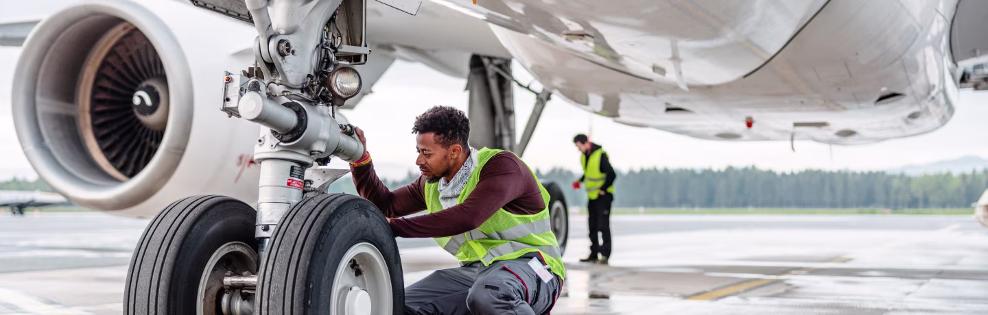 An aircraft engineer repairing and maintaining jet airplane.