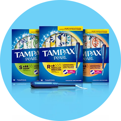 Trois boîtes de tampons Tampax Pearl avec un applicateur à l’avant-plan