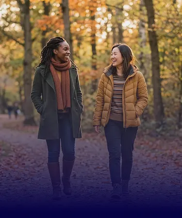 Two smiling women walking together, featuring the most-read Tampax tampon articles