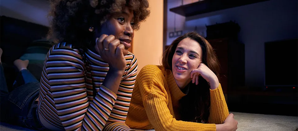 Two happy beautiful women enjoying domestic life talking in evening