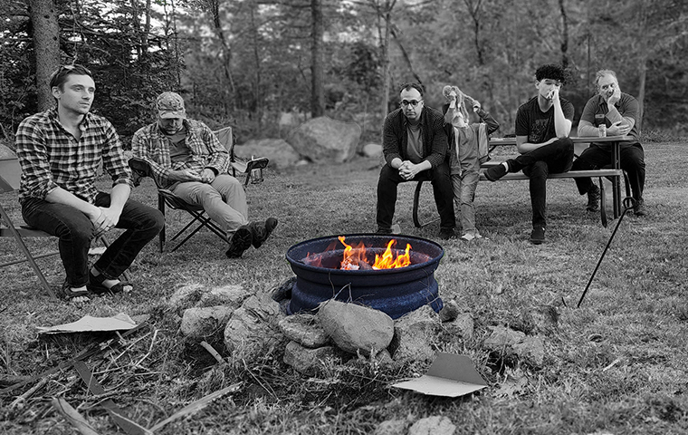 men sitting around a fire