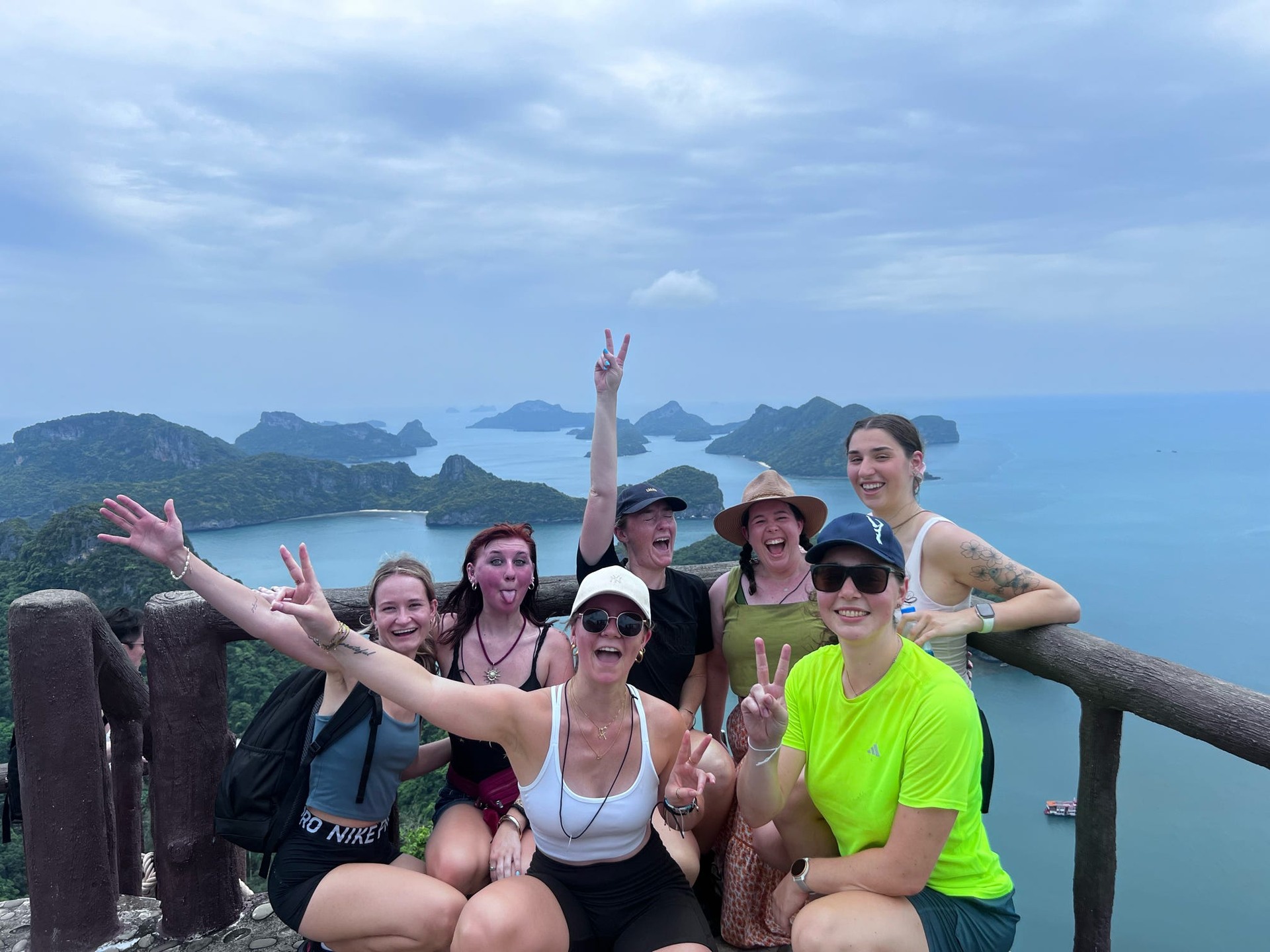 Image - Ally and a group of travellers in Asia A group of travellers posing for a photograph on top of a mountain by the sea in Asia.
