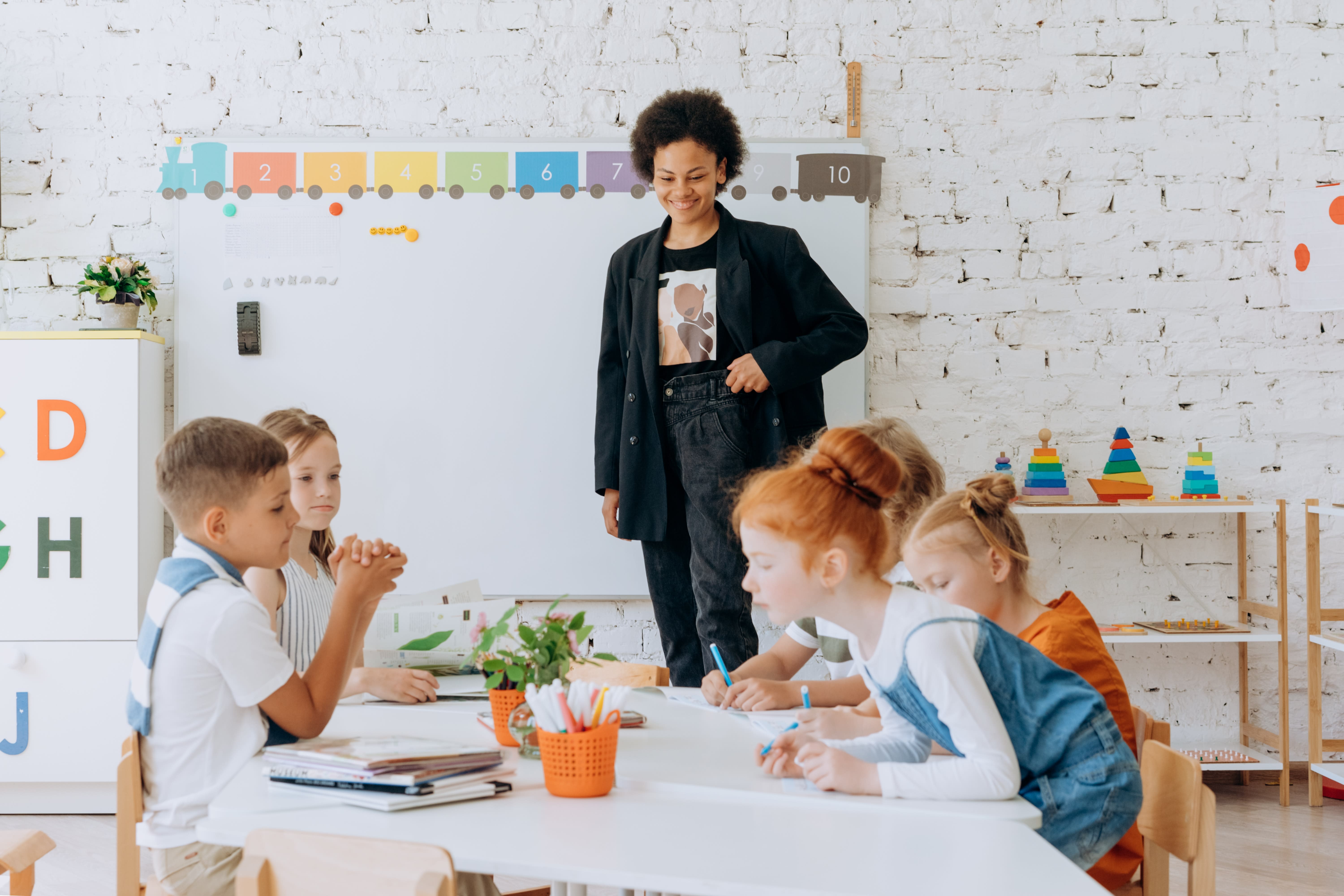 Teacher supervising kids doing their work in a classroom