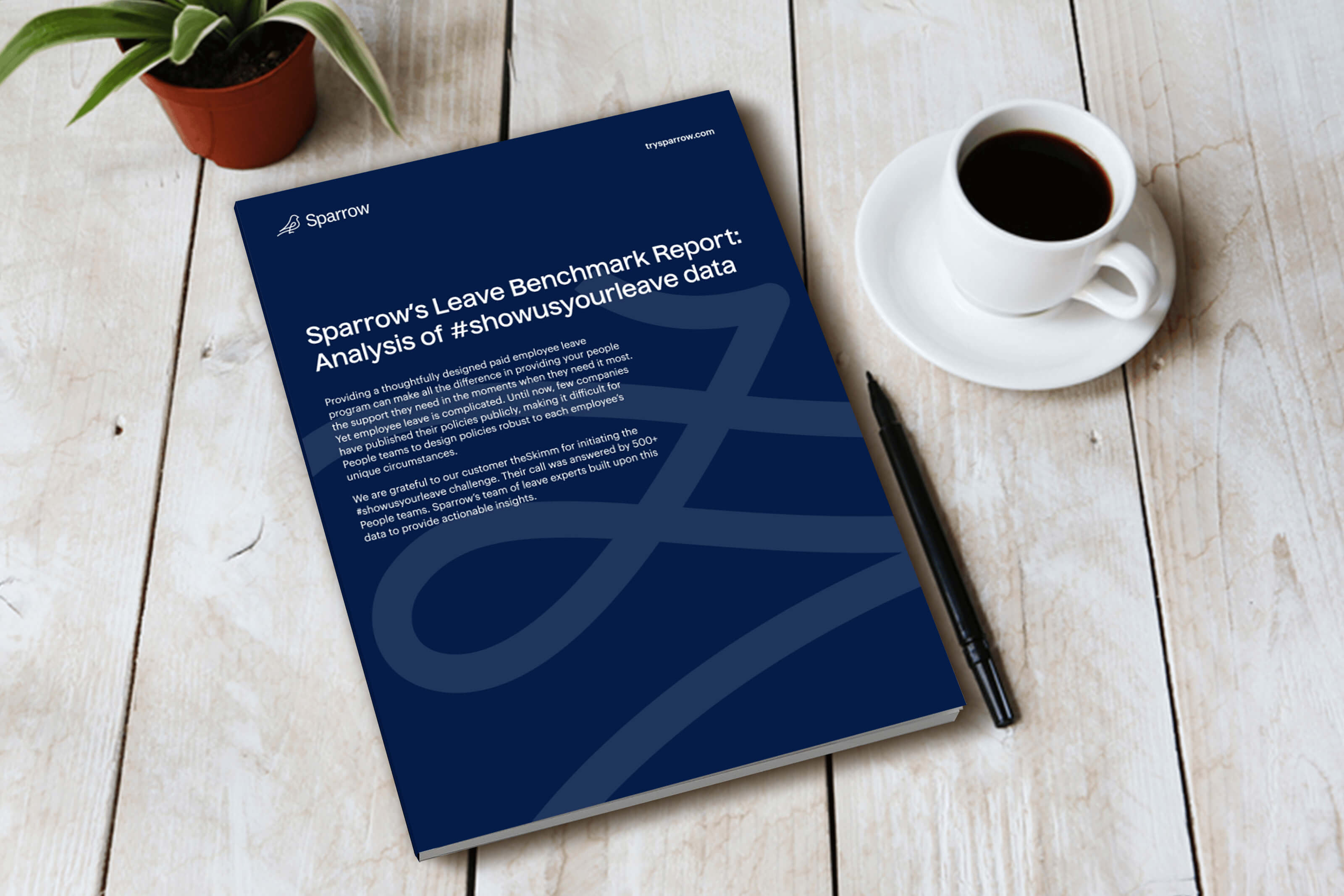 A spiral-bound report titled "Sparrow's Leave Benchmark Report: Analysis of #Showusyourleave data" sits on a wooden table next to a cup of coffee, a pen, and a small potted plant. The cover is navy blue with white text and a minimalist ribbon.