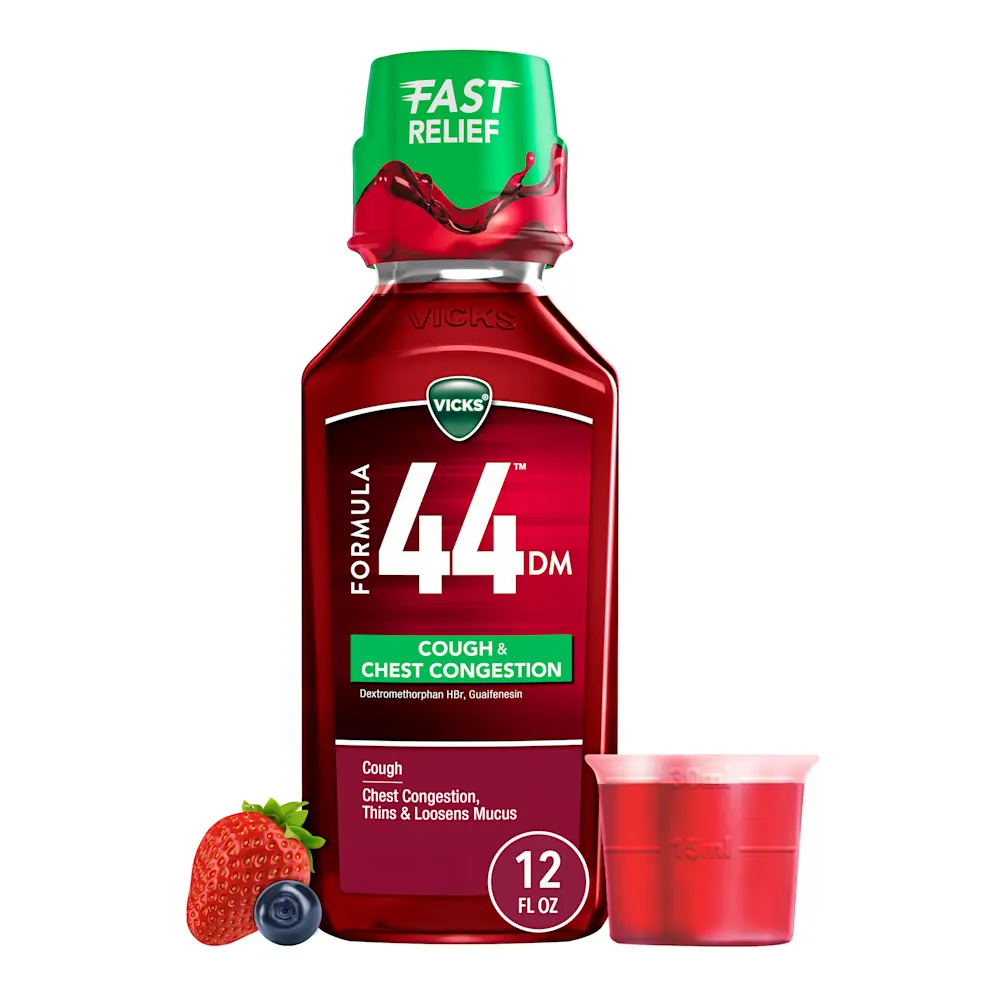 Vicks Formula 44 cough medicine bottle with green cap, red liquid in measuring cup, and fruit garnish beside it.