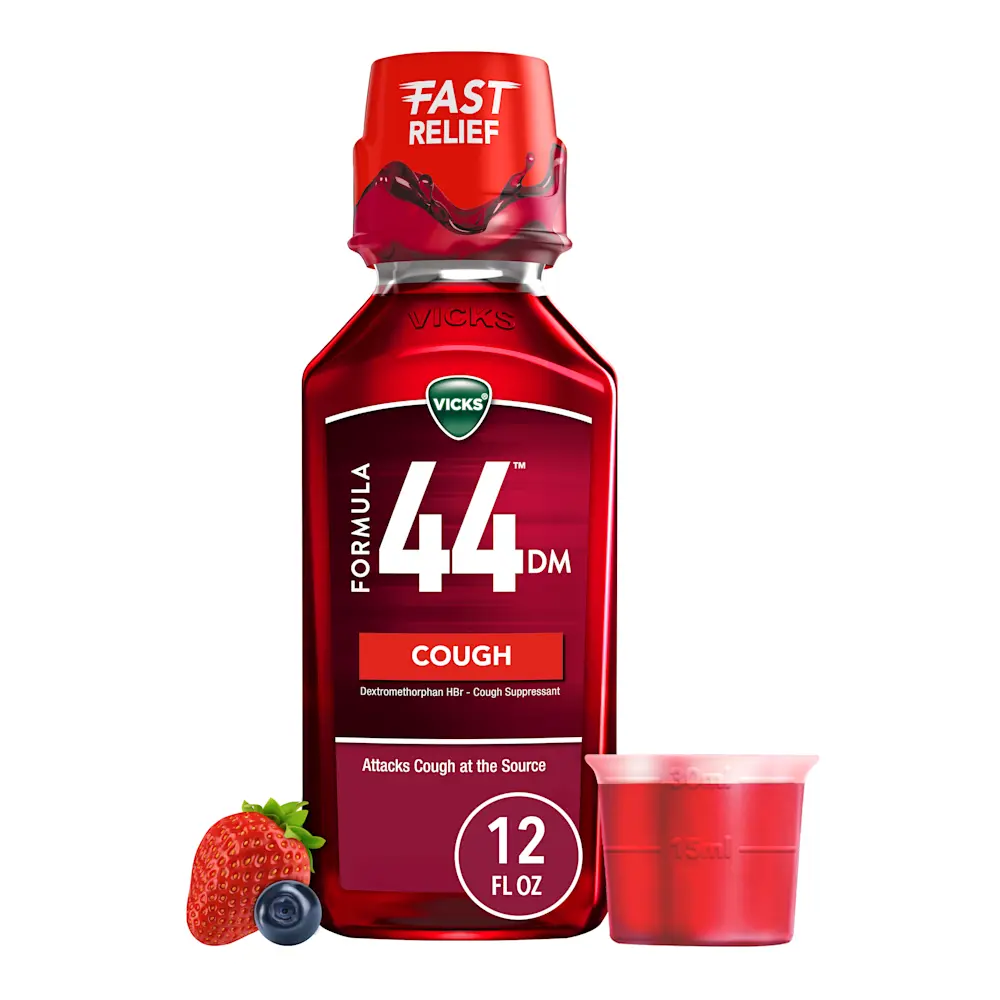 Vicks Formula 44 cough medicine bottle with red liquid, measuring cup, strawberry and blueberry beside it.