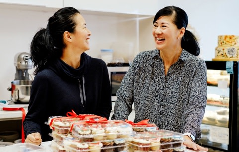 Two women in front of cupcakes