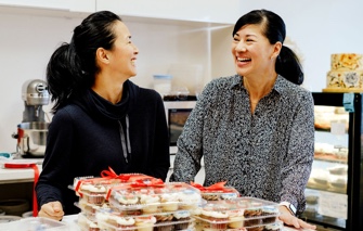 Two women in front of cupcakes