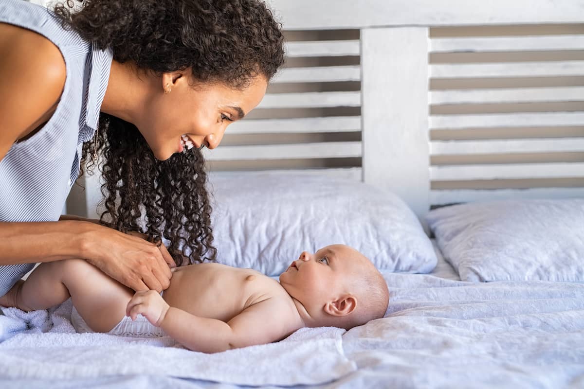 mother changing baby's diapers