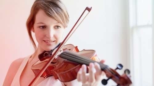 Woman smiling, playing the violin