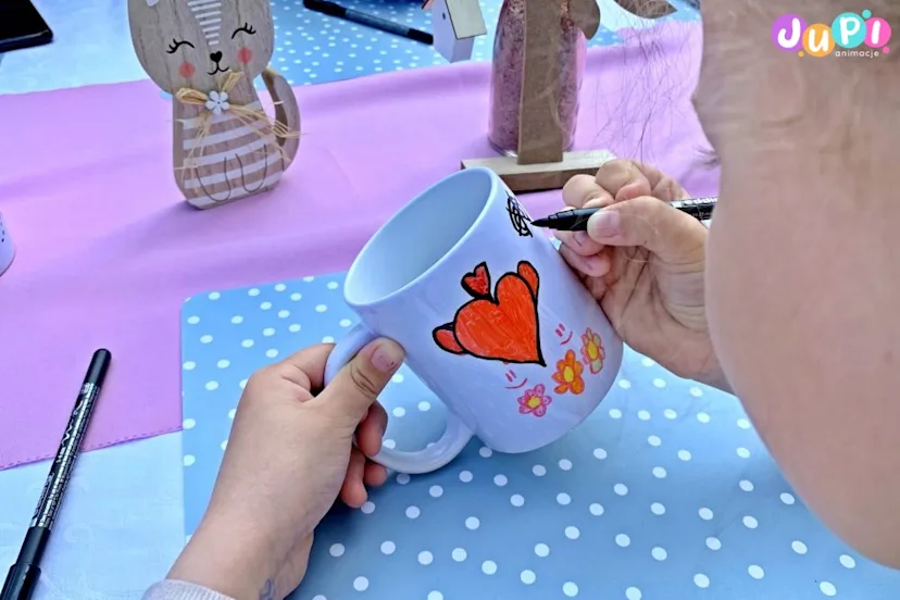 Dziewczynka w trakcie malowania kubków Warsztaty kreatywne dekorowania kubków