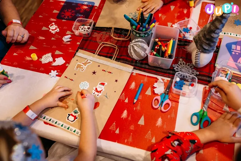 Dzieci dekorujące torbę na prezenty Mikołajkowe warsztaty dekorowania toreb na prezenty podczas mikołajek dla dzieci