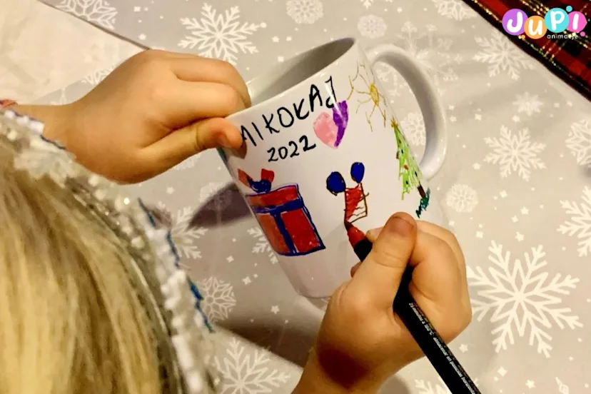 Mikołajki dla dzieci Malowanie kubków przez dzieci podczas mikołajkowych warsztaty artystycznych