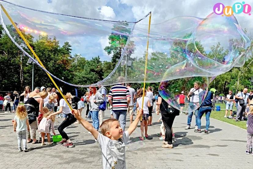 Dziecko robiące ogromne bańki mydlane na festiwalu baniek mydlanych Bubble Show