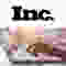 A logo reading "Inc." in black on white, above hands typing on a laptop keyboard.
