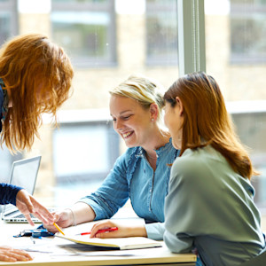 Two INTO Students being guided by their teacher on their work Two INTO Students being guided by their teacher on their work