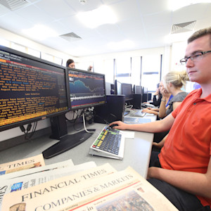INTO Students working on a computer, Several copies of the Financial times are on the desk INTO Students working on a computer, Several copies of the Financial times are on the desk