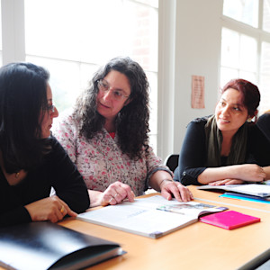 Teacher helps international students in classroom at University of Exeter Teacher helps international students in classroom at University of Exeter