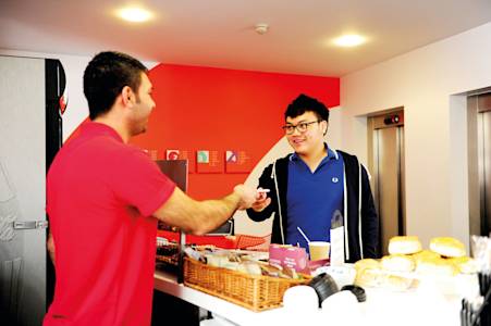 International student being helped by staff at the INTO cafe International student being helped by staff at the INTO cafe