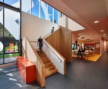 Inside INTO Centre showing staircase and cafe with international students Inside INTO Centre showing staircase and cafe with international students