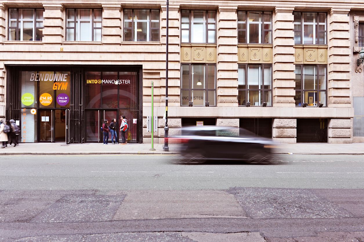 Exterior view of the INTO Centre in Manchester with international students outside
