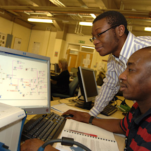 Two INTO International look at a circuit diagram on a computer together Two INTO International look at a circuit diagram on a computer together