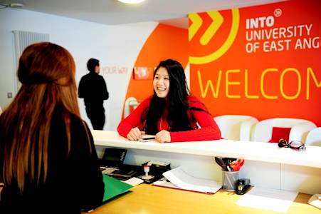 International student talking to staff at the INTO Centre welcome desk International student talking to staff at the INTO Centre welcome desk