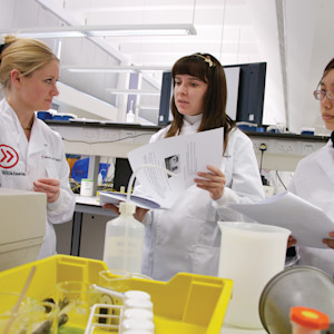 Students in lab coats with equipment in lab. Students in lab coats with equipment in lab.