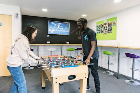International students playing table football in Liberty Point breakout area International students playing table football in Liberty Point breakout area