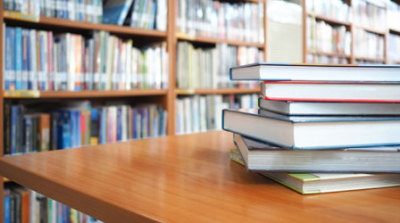 Stack of books on desk in school library