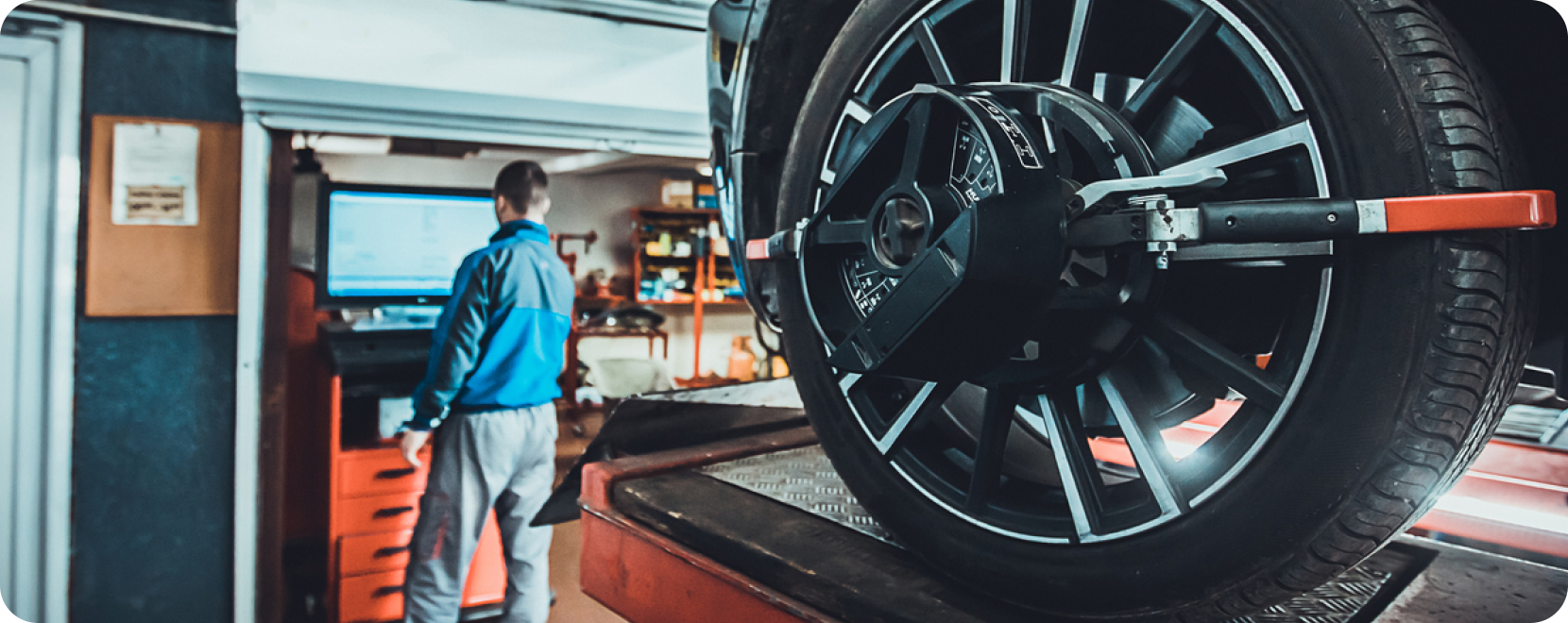 man in autobody shop and tires