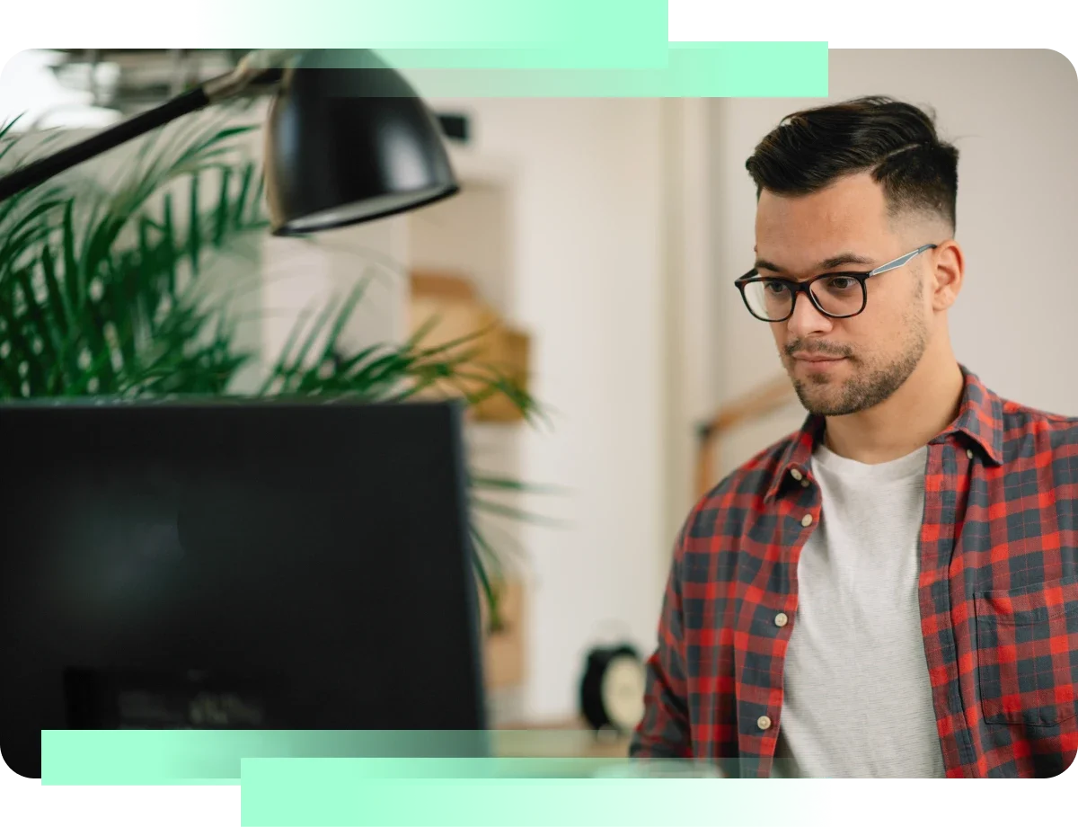 man in plaid shirt working on computer