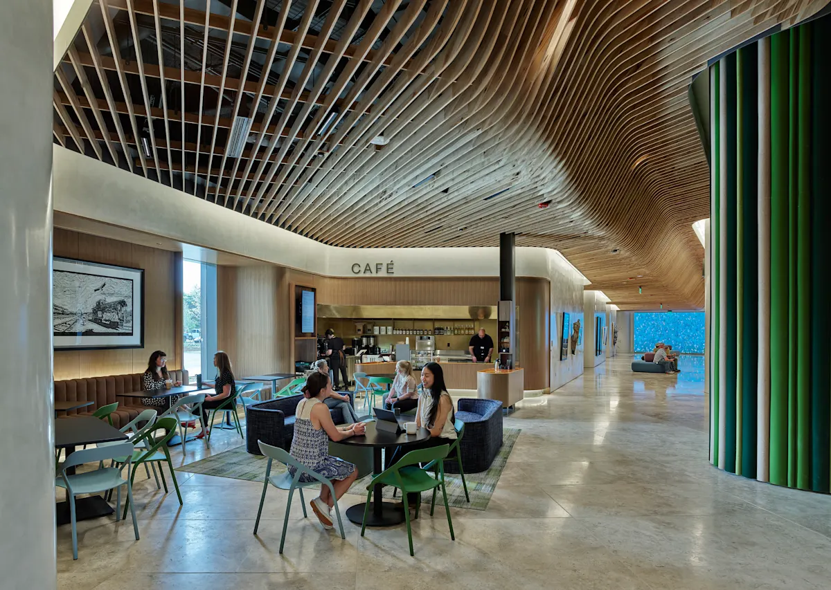 Zoomed out image of the cafe on the first floor. A few people sit at tables interacting with each other.