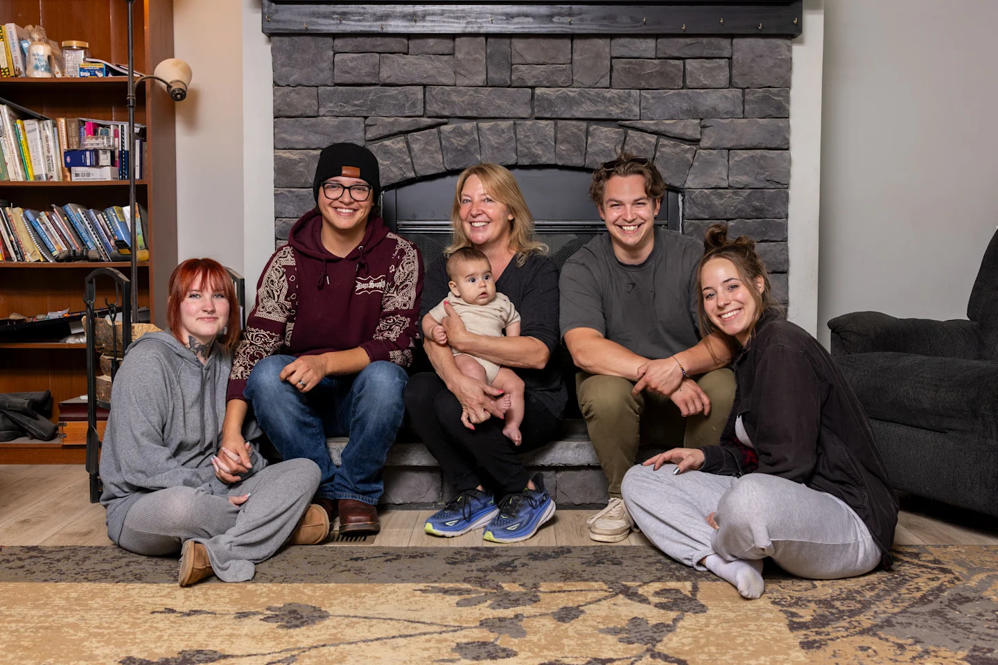 Shannon Navarrette posing with her kids and grandson in front of her fireplace
