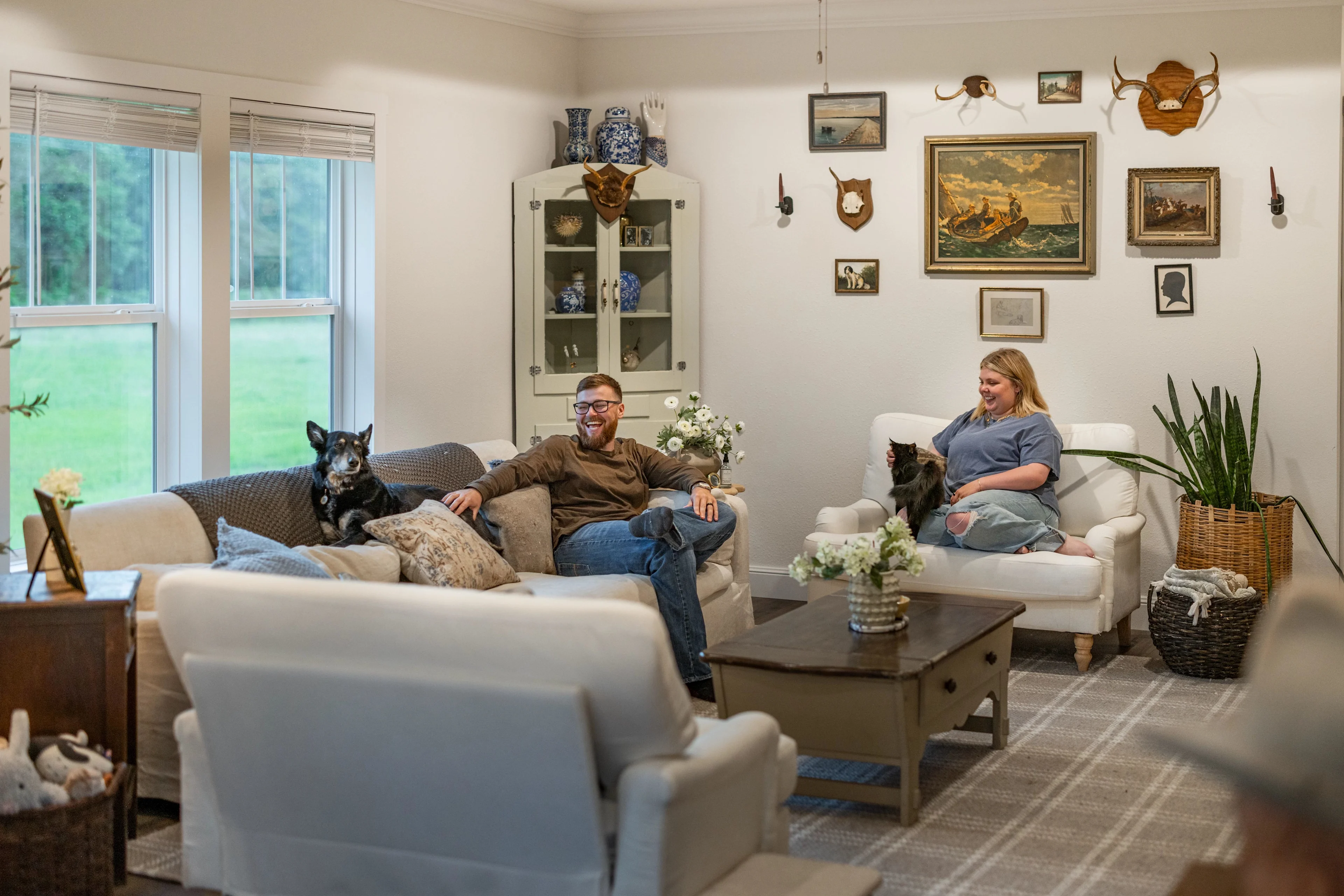 Koven and Josh Bruce sitting in their living room with their pets.