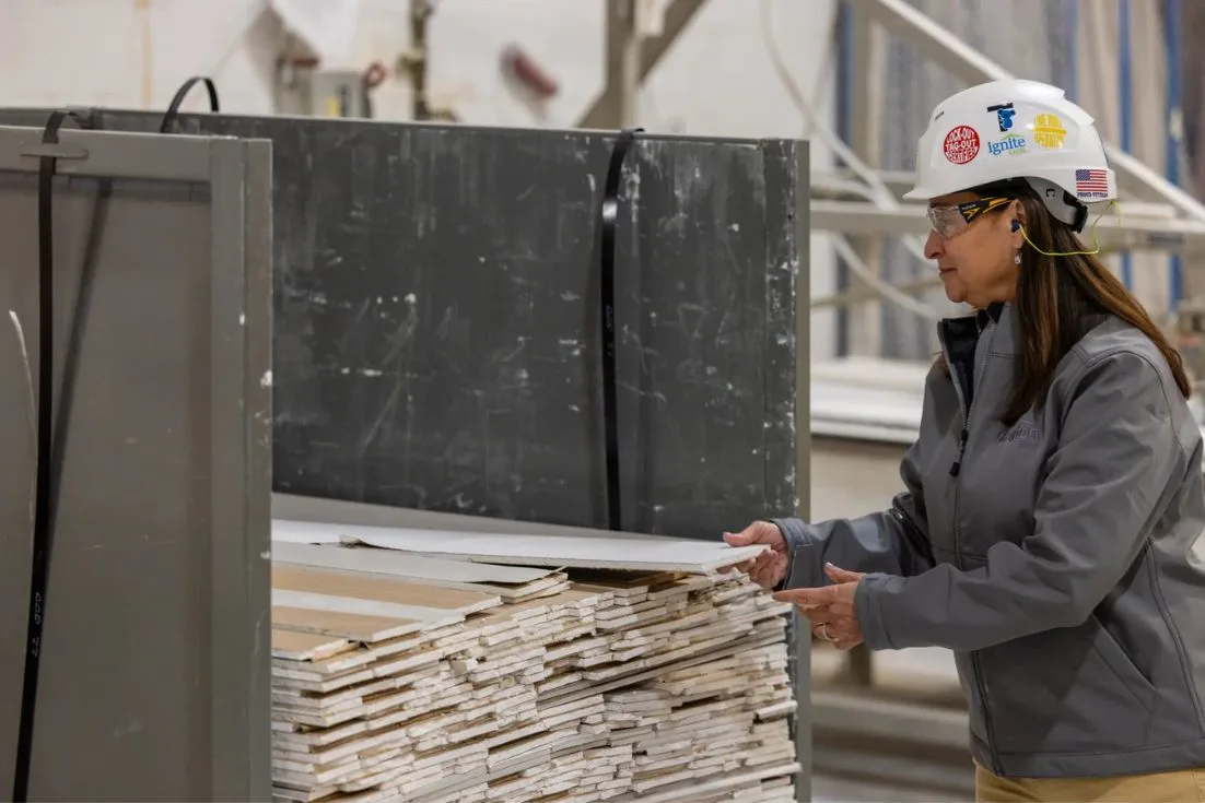 Lisa pulling out a panel of gypsum in a building facility.