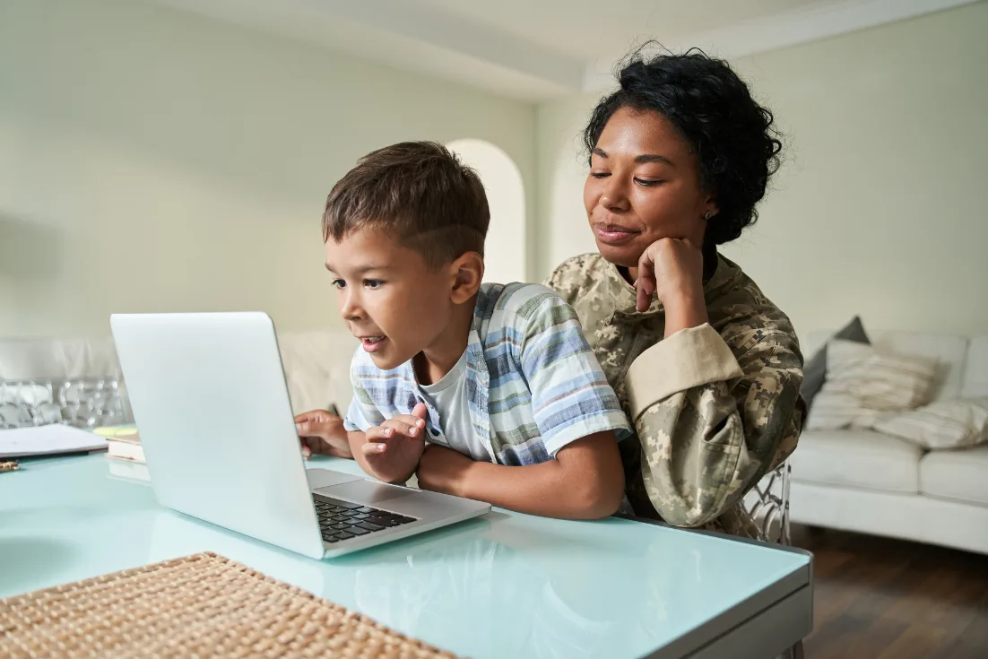 A mom and son look online to assess VA loans online for their new construction home.