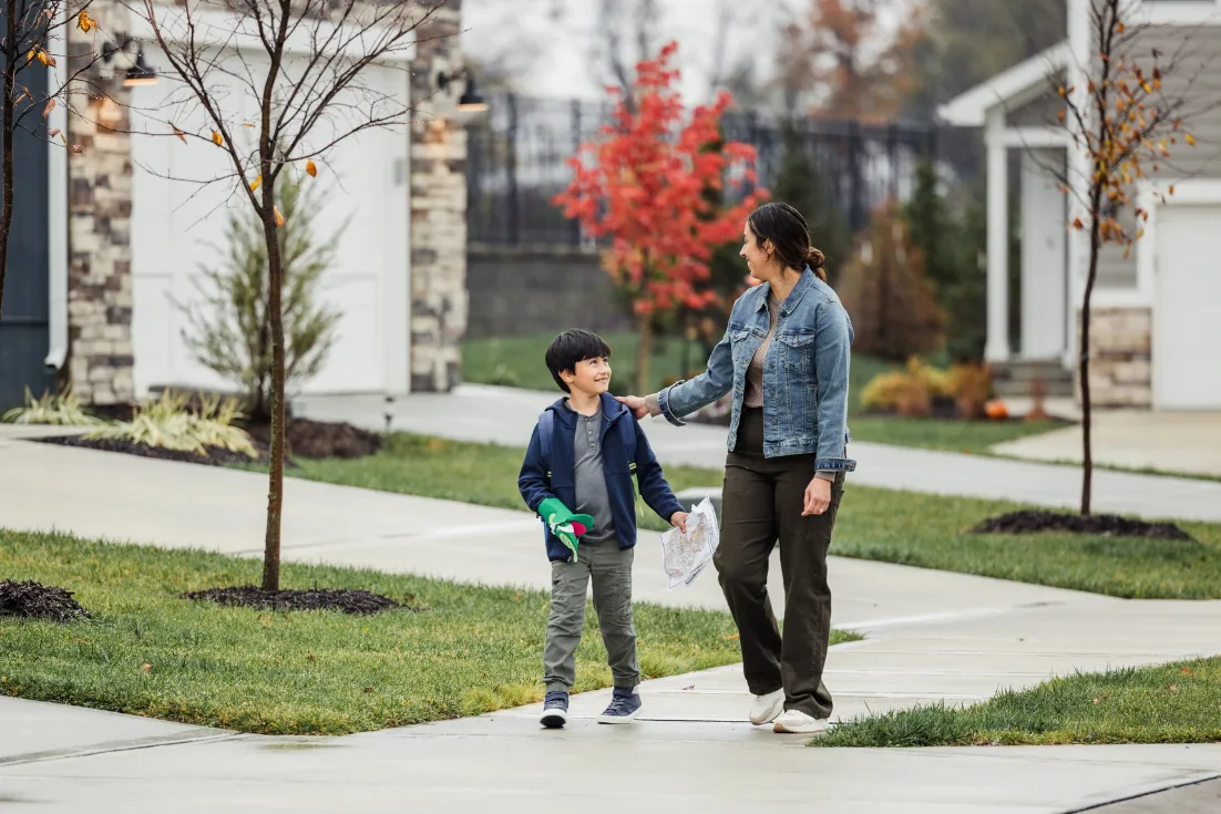 Mother and son walk in their new construction neighborhood after school.