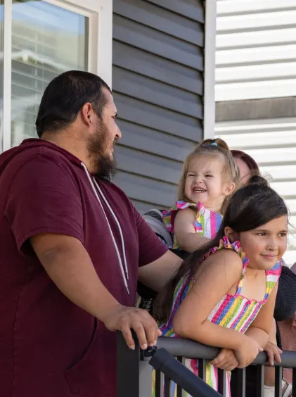 Juan Cebreros is turned to smile at his children on the porch.
