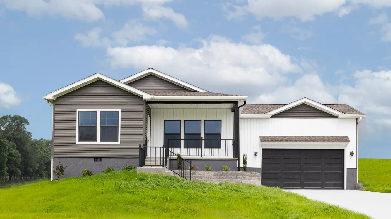 An exterior of a CrossMod® home on small grassy hill with gray and white siding, a front porch, and an attached garage.