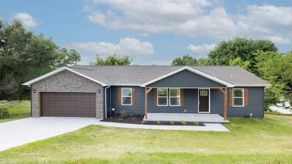 This new construction modern CrossMod home has a front porch, blue siding exterior and attached garage on private land.