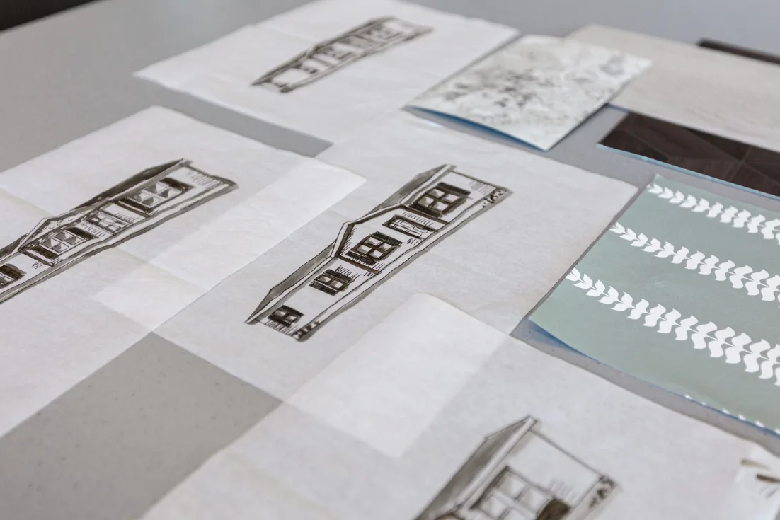 Drawings of manufactured homes and sample materials lay on a table.