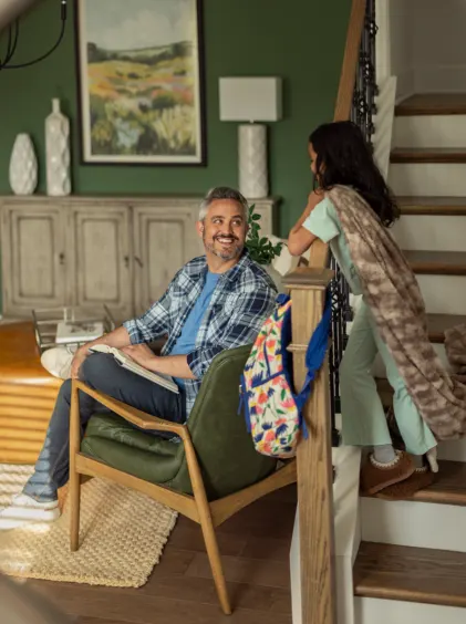 Dad and daughter share a moment in the living room next to stairs in their new construction home.