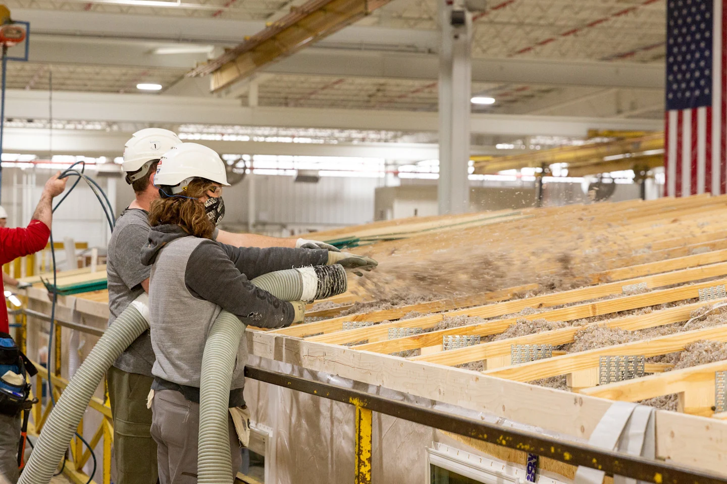 Team Members blow insulation into ceiling of a home