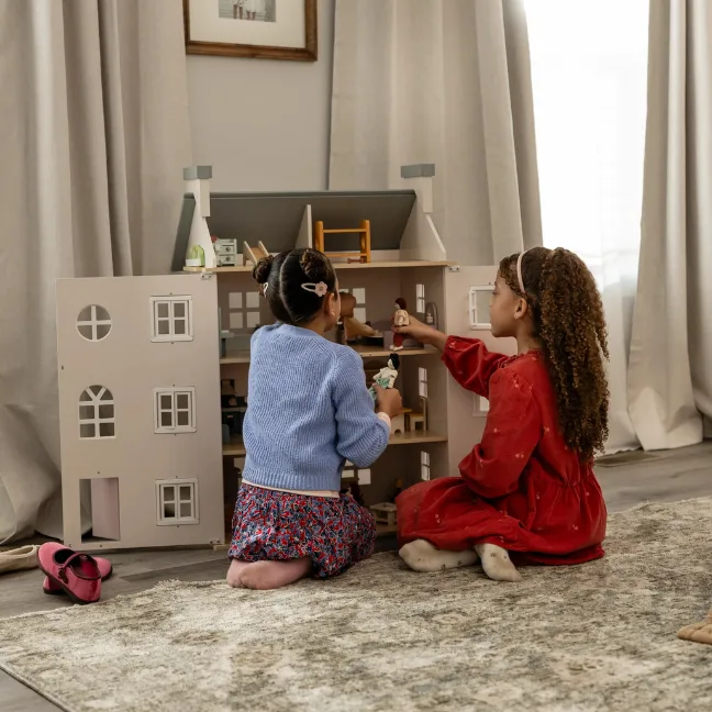 Two girls play with a doll house inside their new construction home from Clayton.